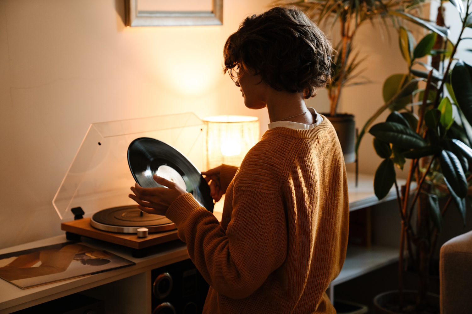 Mujer pone un vinilo en un tocadiscos